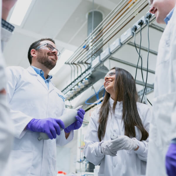 A group of people in lab coats and gloves.